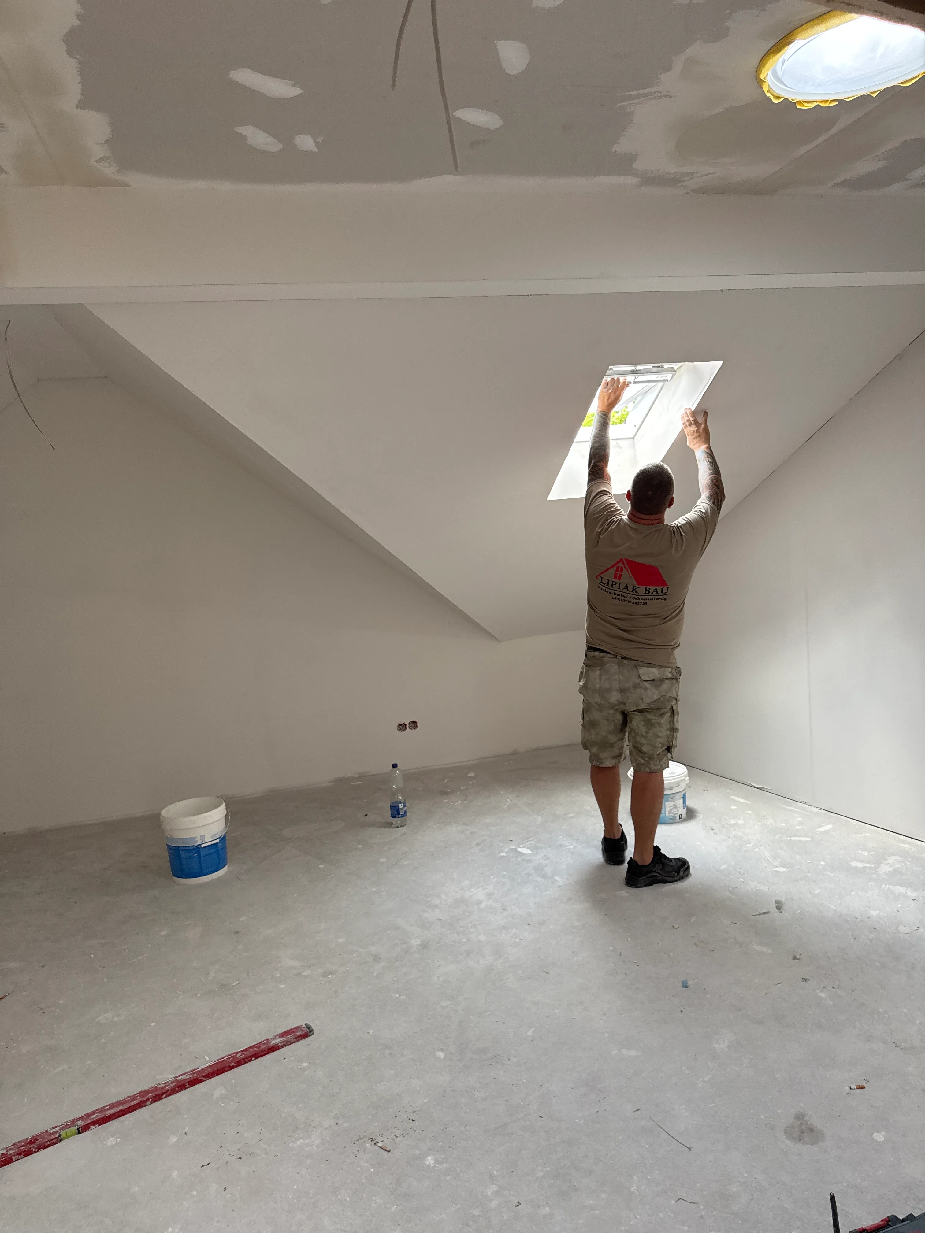 Handwerker montiert Dachfenster im Rohbau